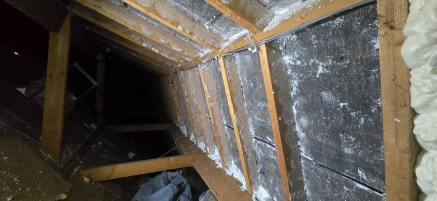 Loft roof space during professional spray foam insulation removal, UK