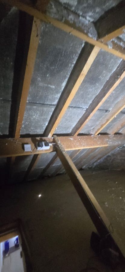 Loft roof space during professional spray foam insulation removal, UK