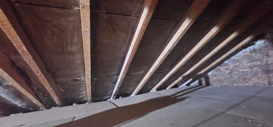 Loft roof space during professional spray foam insulation removal, UK